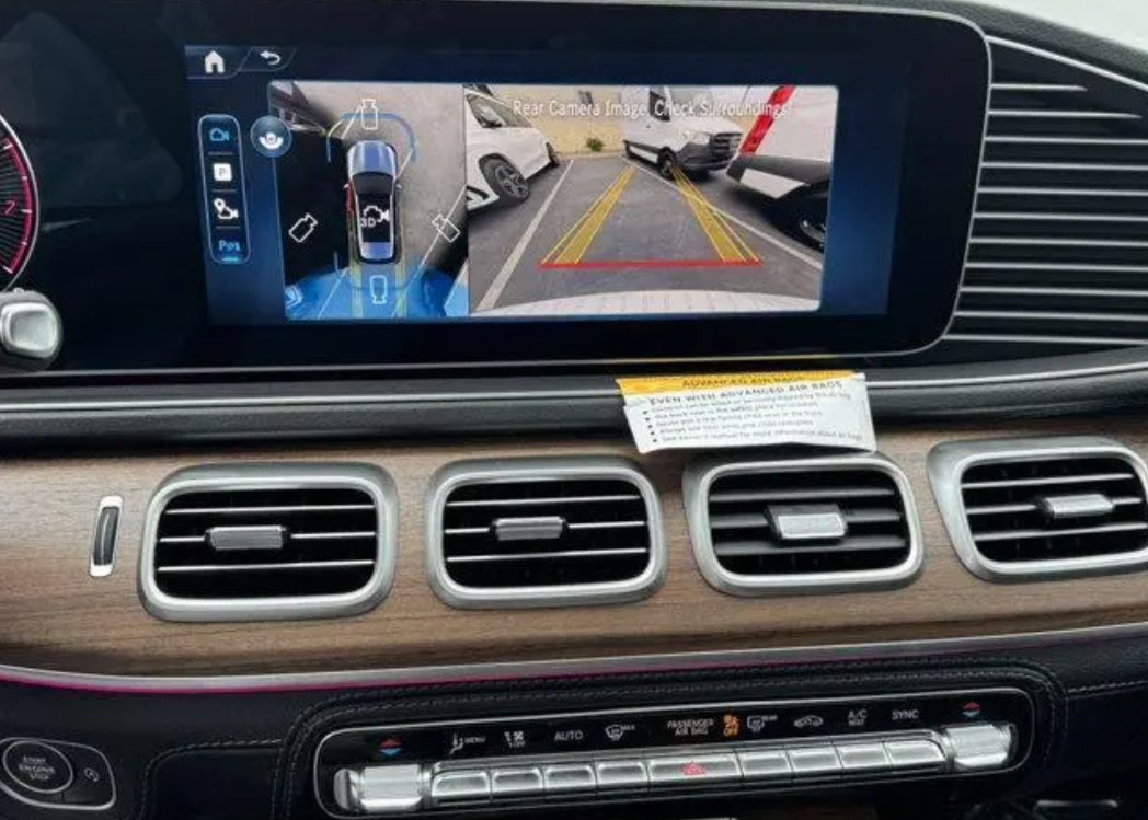 Car dashboard with a navigation screen displaying a parking aid system.