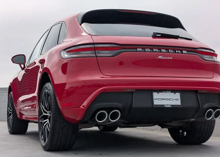 Red Porsche Macan SUV shown from a rear three-quarter angle on a gray background