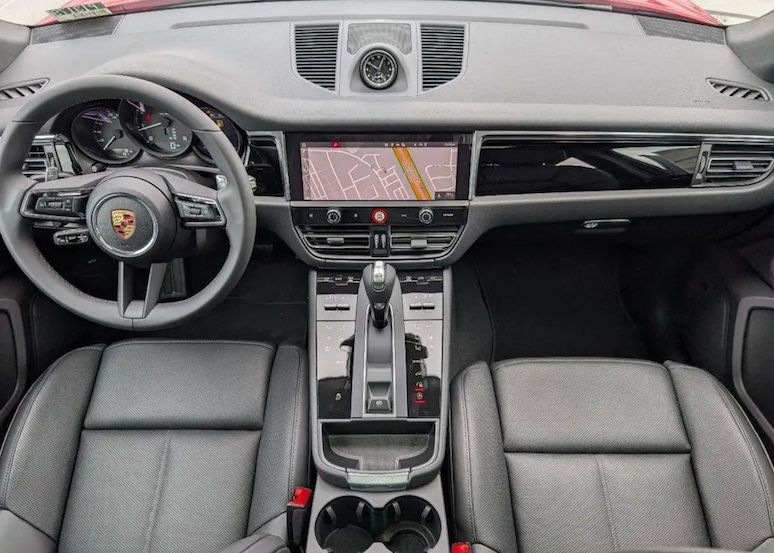 Car interior with steering wheel, dashboard, and center console.