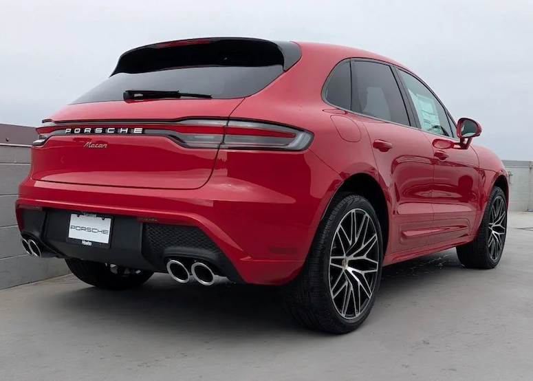 Red Porsche Cayenne parked on a concrete surface with a gray background