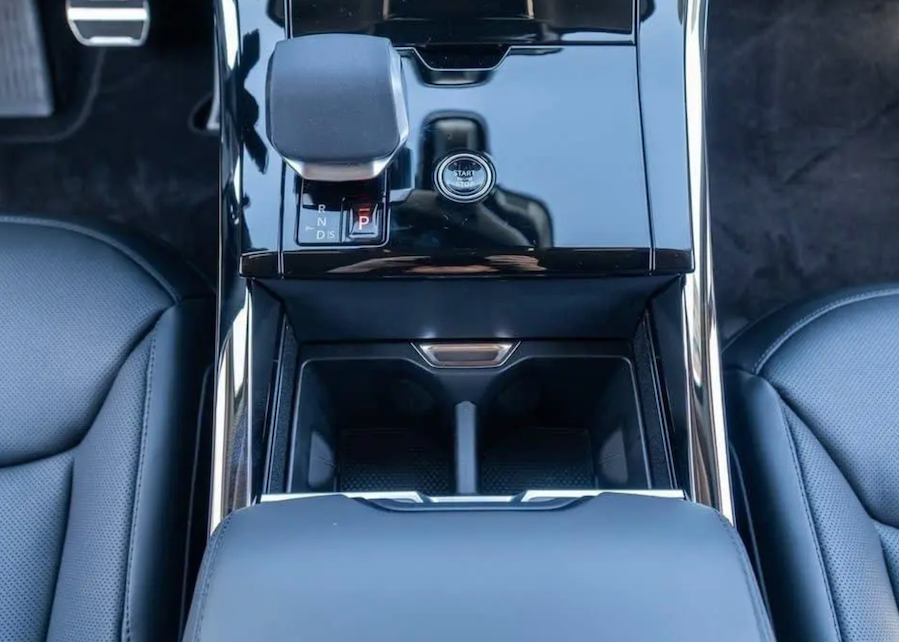 Close-up of a car's center console with cup holders and control buttons.