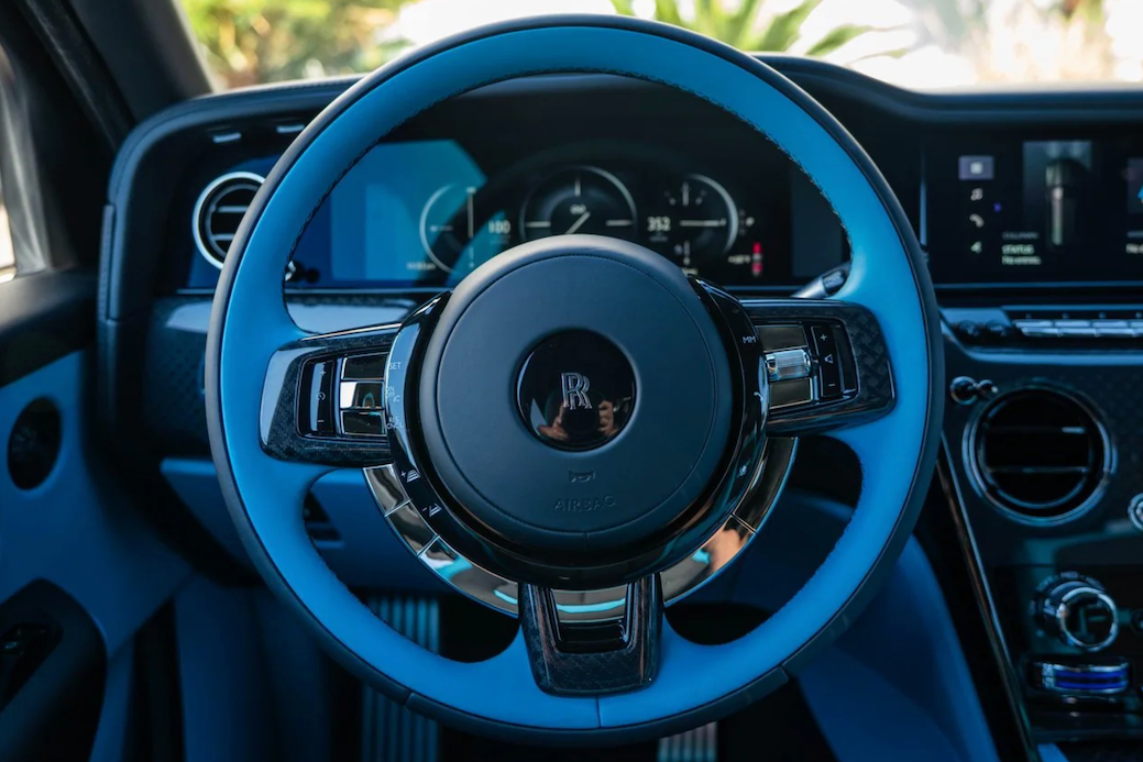 Close-up of a car's steering wheel and dashboard with a visible brand logo.
