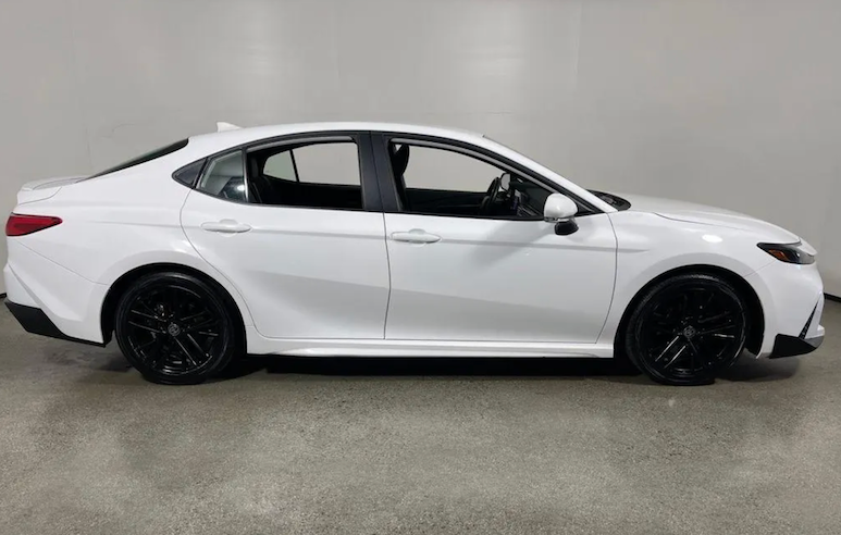 White car with black rims on a gray floor and light gray background
