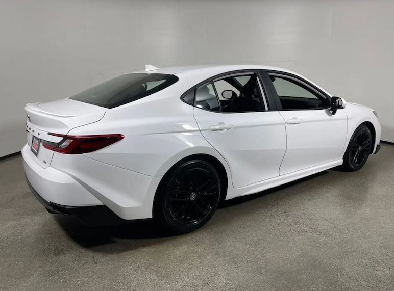 White car with black rims on a gray floor and white wall background