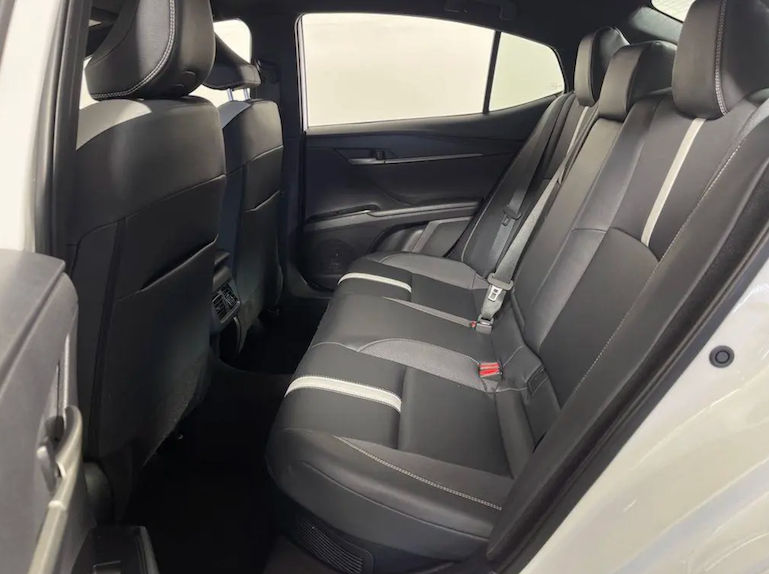 Back seat of a car with gray seats and visible door panel.