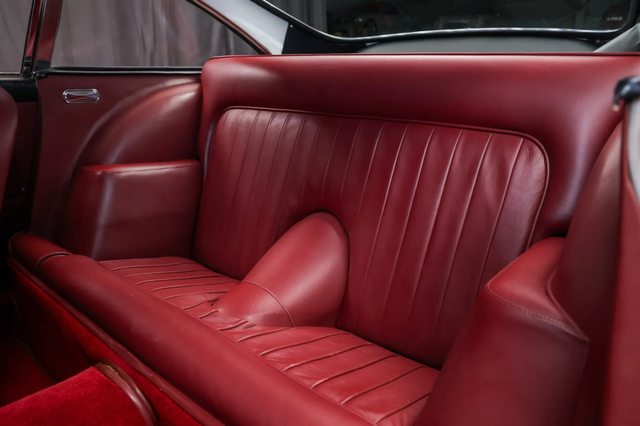 Close-up of a red leather car seat with visible stitching