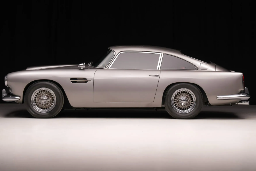 Side view of a classic silver car on a dark background
