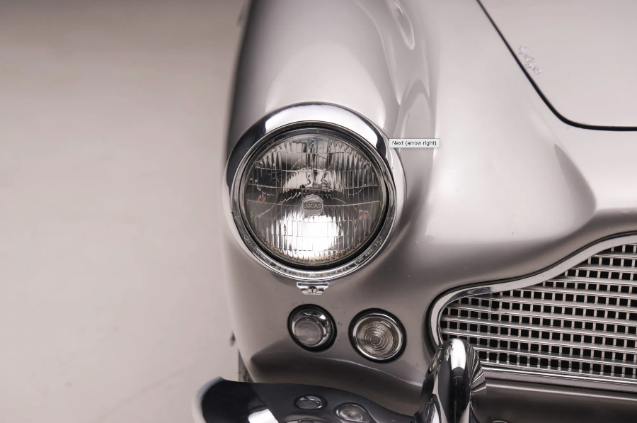 Close-up of a car's headlight and grille on a light gray background