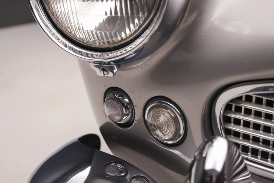 Close-up of a car's headlight and grille on a light gray background