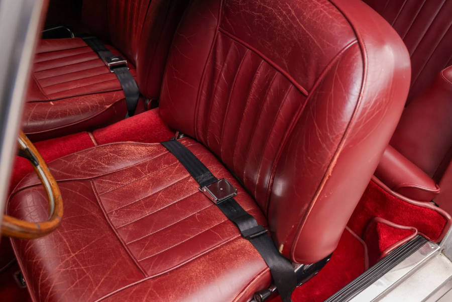 Close-up of red leather car seats with a seatbelt.