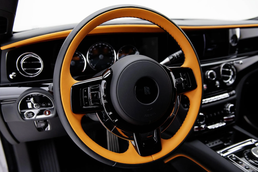 Steering wheel and dashboard of a luxury vehicle with brown and black design.