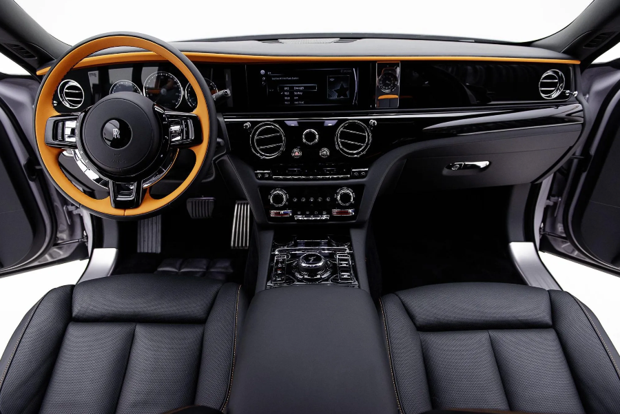 Luxury car interior with black leather seats and wooden dashboard.