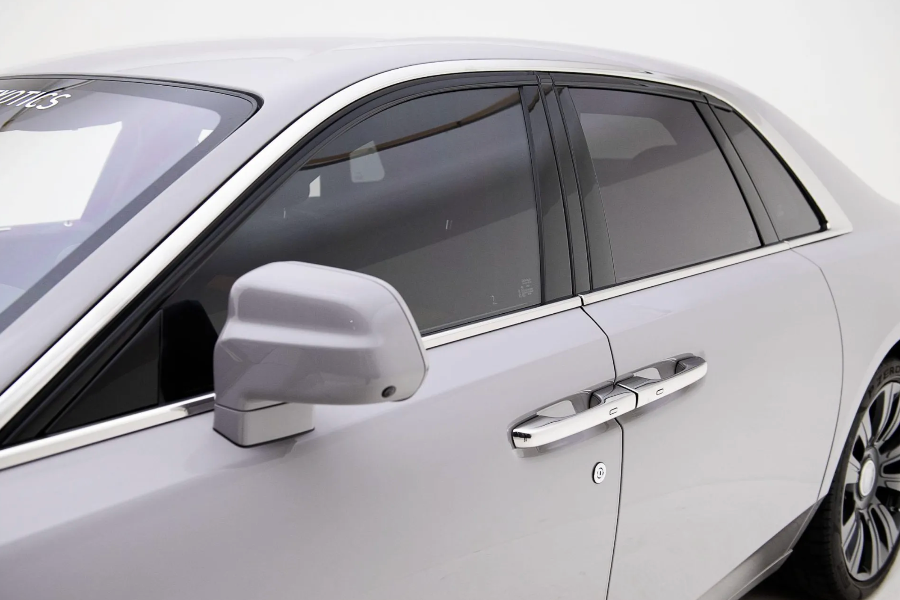 Close-up of a car door with mirror and handle on a white background