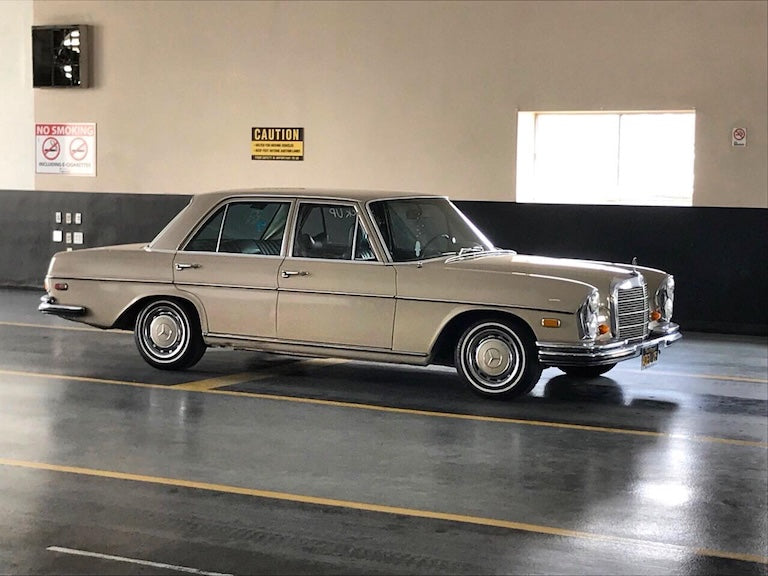 Vintage car parked in the usa auction garage with caution sign on wall