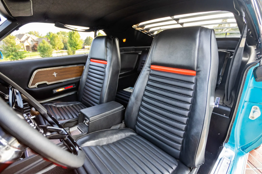 Car interior with black leather seats and wooden dashboard.