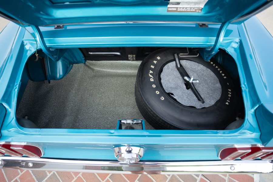 Open car trunk with a spare tire and Goodyear logo.