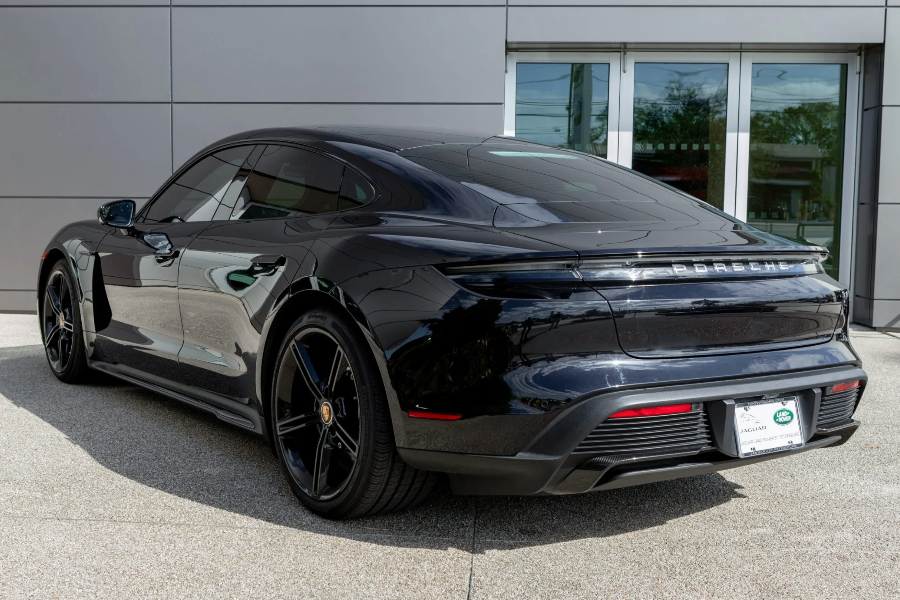 Black luxury car parked in front of a modern building