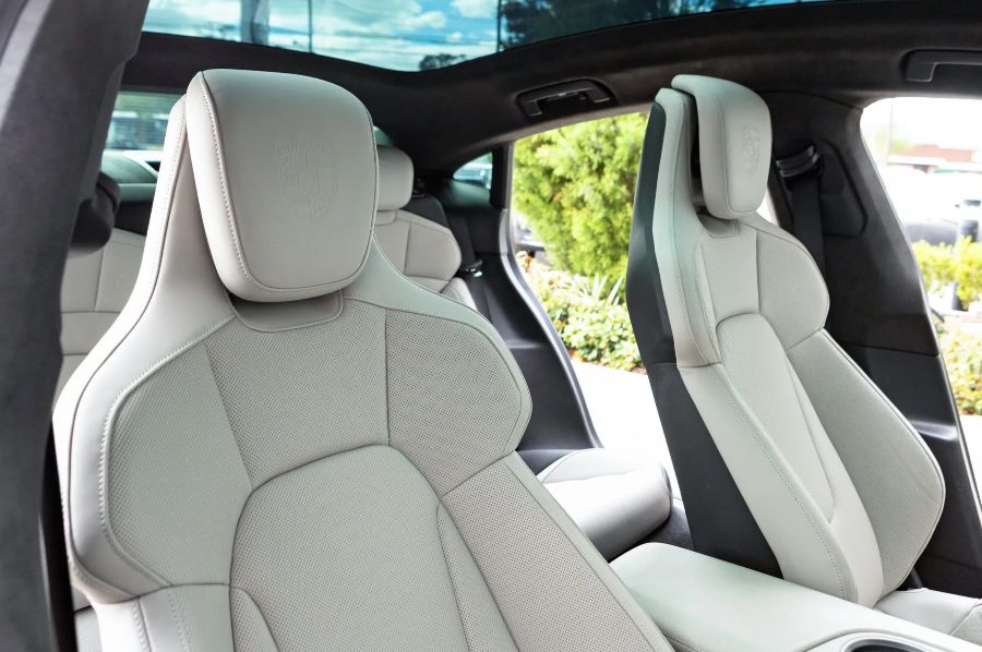 Close-up of white car seats with a blurred outdoor background
