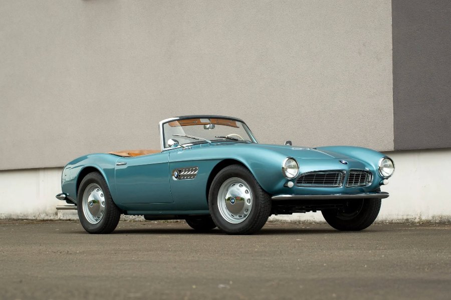 Vintage blue convertible car parked on a gray surface with a plain background