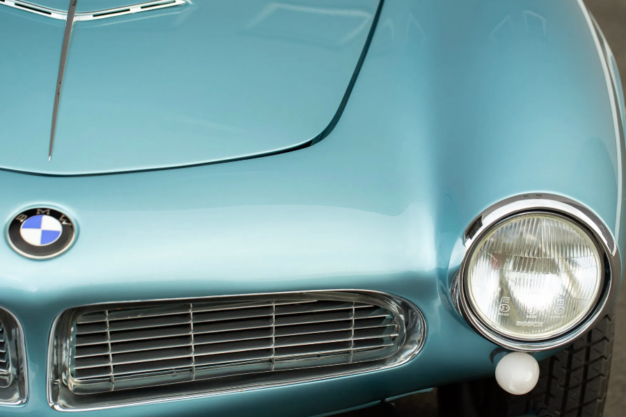 Close-up of a vintage BMW car's front grille and headlight.
