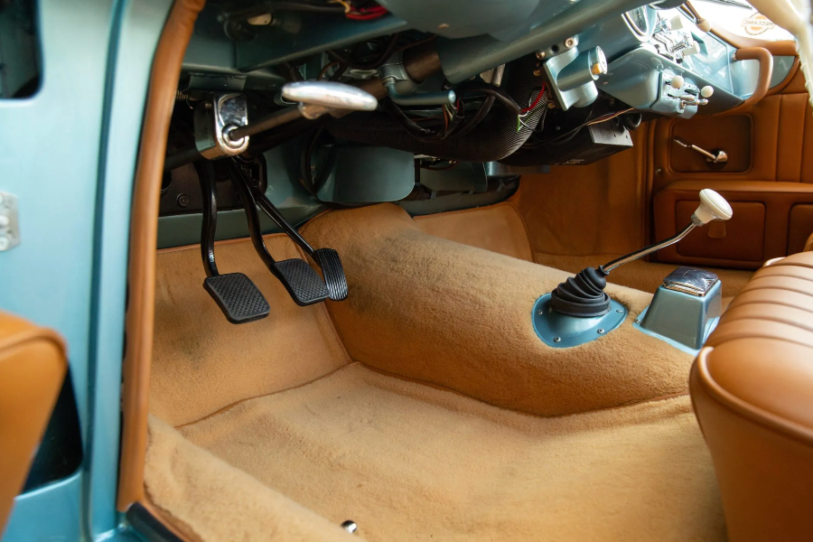 Close-up of a car's interior with pedals and gear shift in a vehicle.