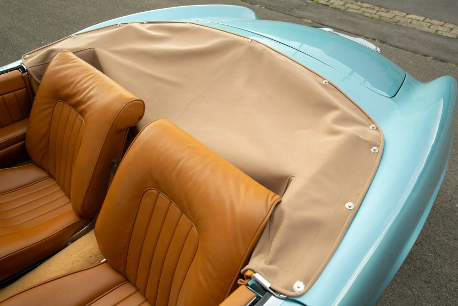 Close-up of a vintage car's brown leather seats and light blue interior.