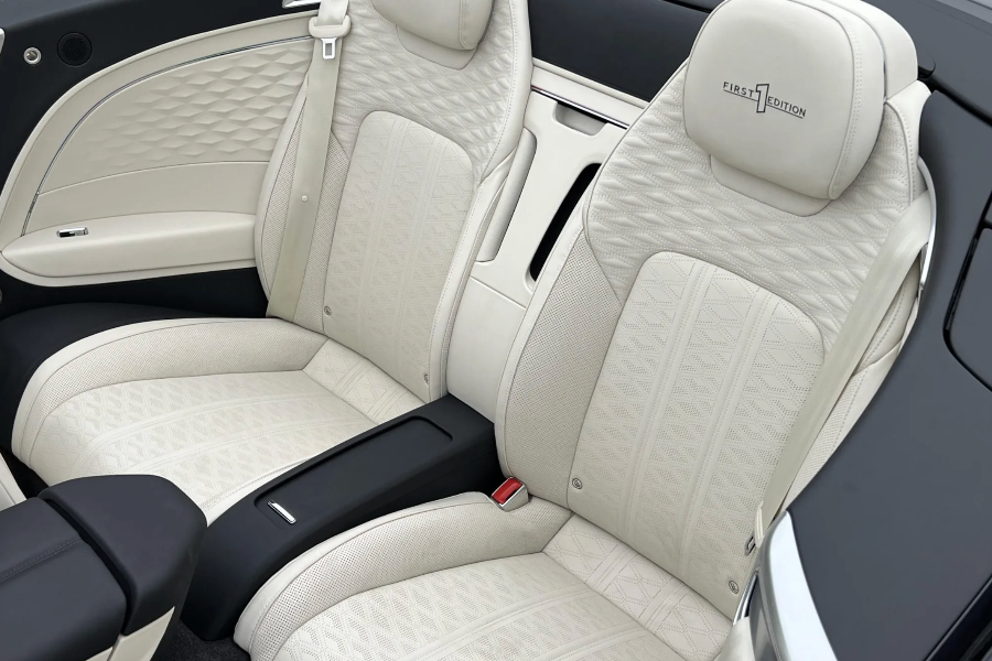 Luxury car interior with beige quilted leather seats and black accents.