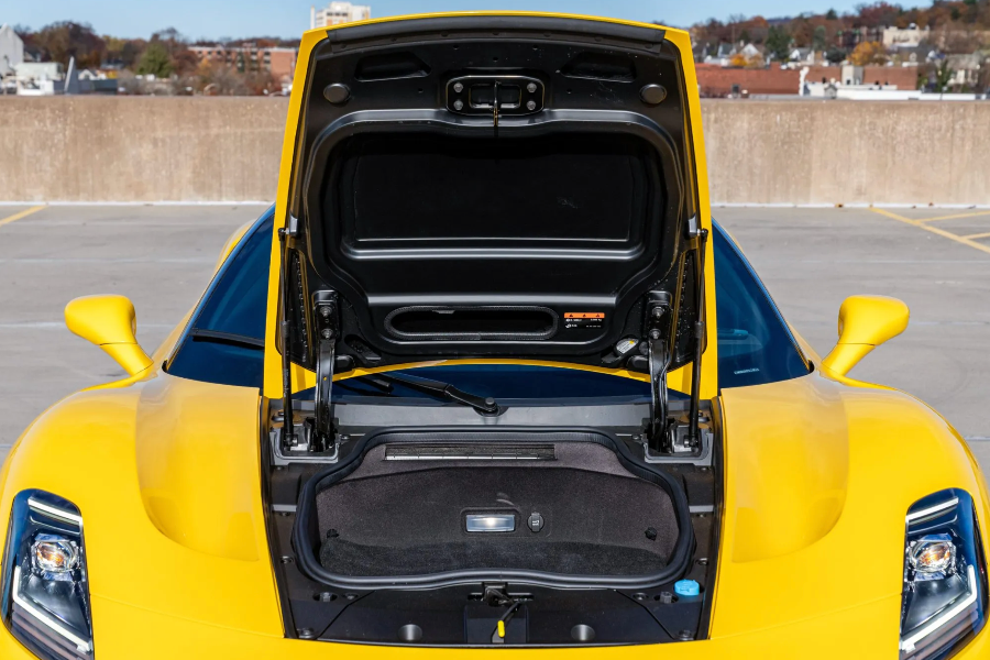 Yellow car with open trunk in a parking lot