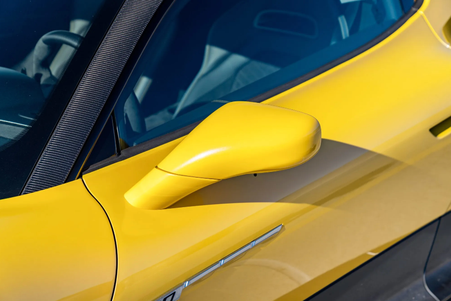 Close-up of a yellow car's side mirror and door