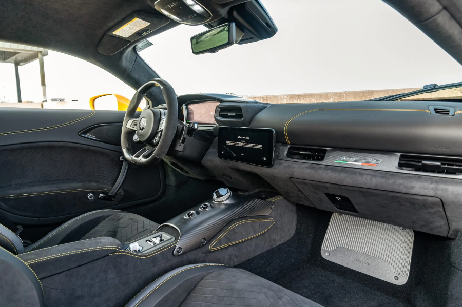 Car interior with steering wheel and dashboard in a blurred outdoor setting