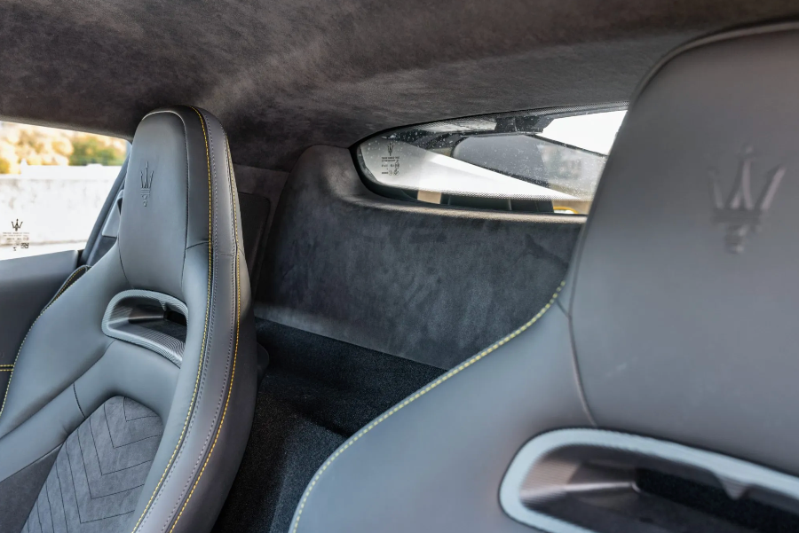 Gray car interior with visible Maserati logo on headrest