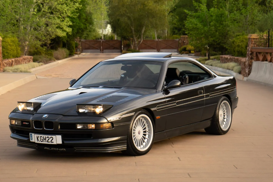 Black BMW car on a road with trees in the background