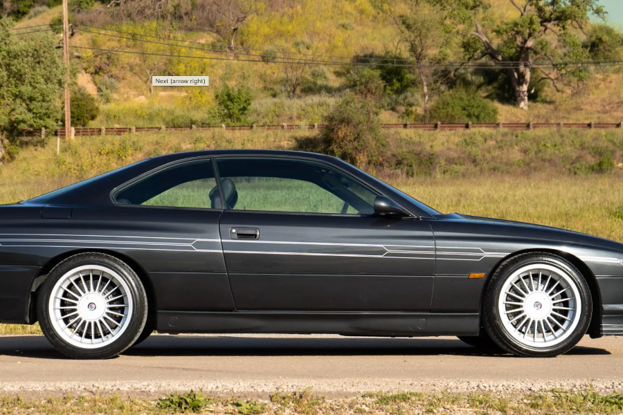 Black BMW car on a road with a scenic background