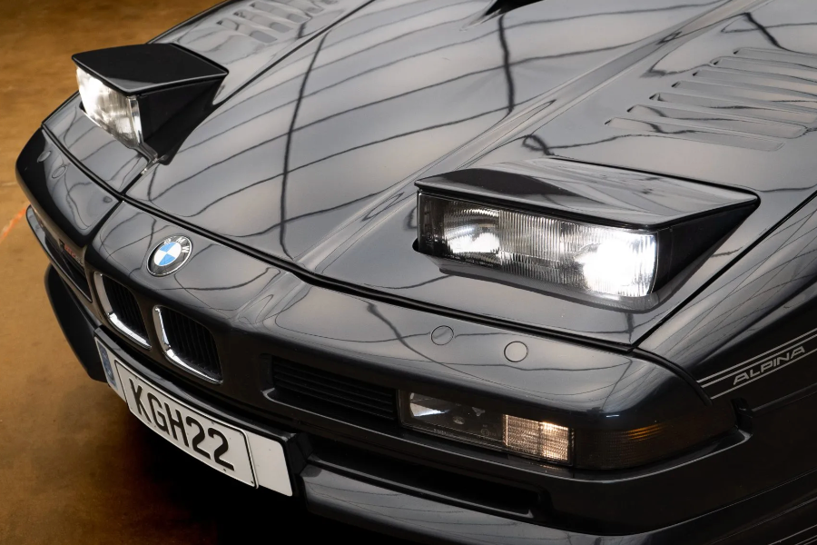 Close-up of a BMW car's front grille and headlights with a visible license plate.