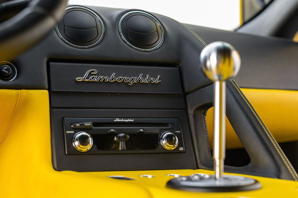 Close-up of a Lamborghini car interior with dashboard and gear shift.