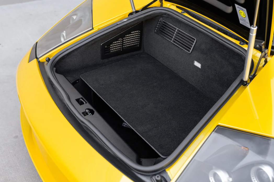 Open trunk of a yellow car with black interior