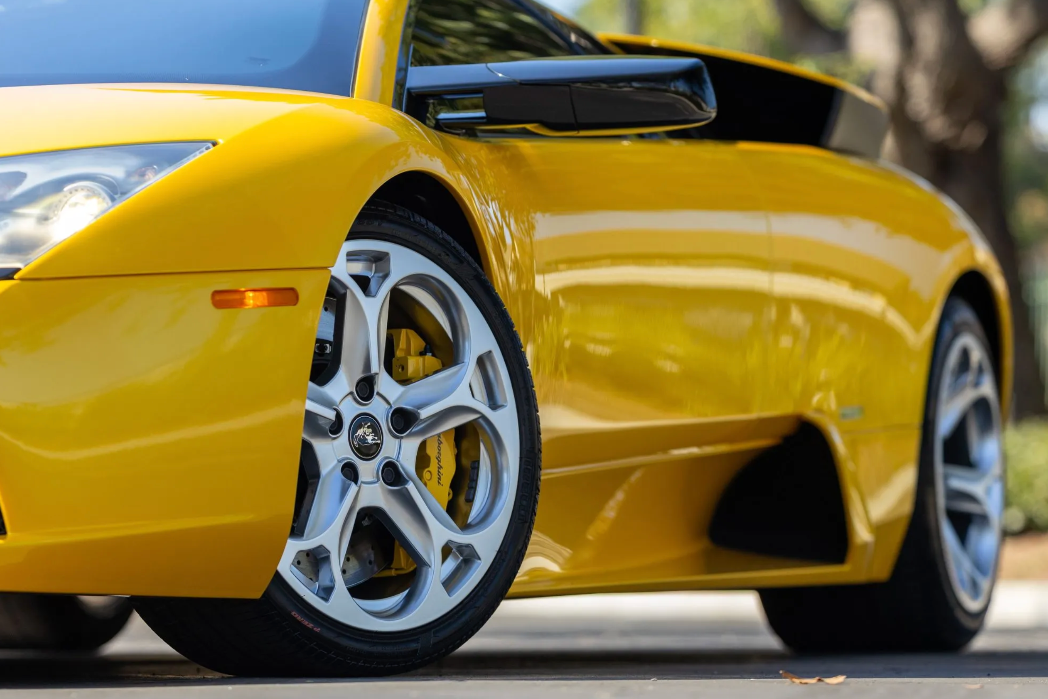 Yellow sports car with a close-up of a wheel on a blurred background