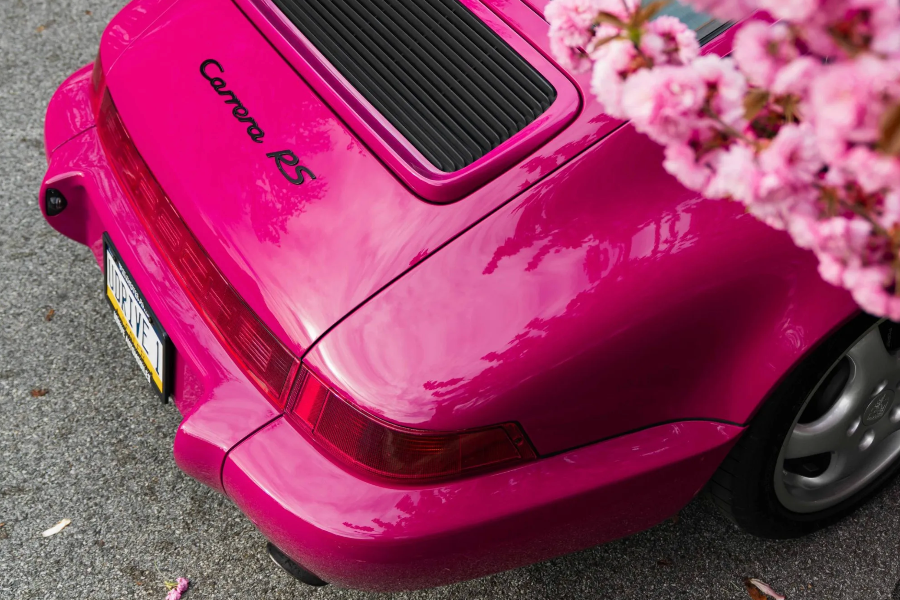 Pink Porsche 911 Carrera RS with a flower in the foreground
